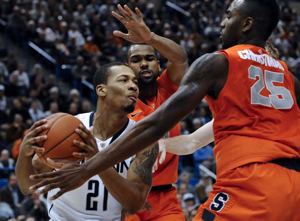 Connecticut's Omar Calhoun, left, is pressured by Syracuse's James Southerland, center, and Syracuse's Rakeem Christmas, right, during the second half of an NCAA college basketball game in Hartford, Conn., Wednesday, Feb. 13, 2013. Connecticut won 66-58. (AP Photo/Jessica Hill)