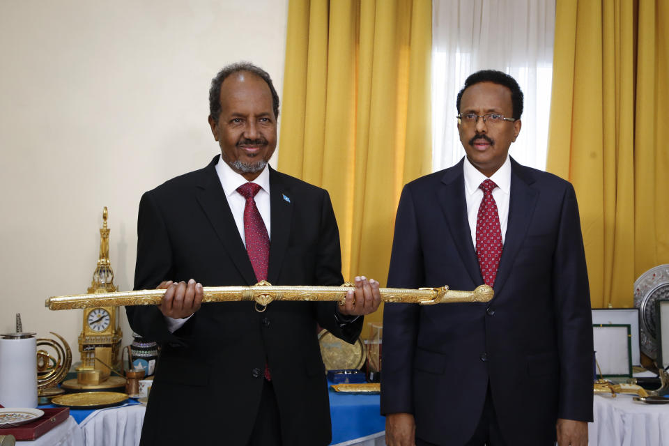 New President of Somalia Hassan Sheikh Mohamud, left, receives a ceremonial sword from former leader Mohamed Abdullahi Mohamed, right, during an official handover ceremony at the presidential palace in Mogadishu, Somalia, Monday, May 23, 2022. Mohamud was elected to the nation's top office in a protracted contest decided by legislators on Sunday, May 15, 2022. (AP Photo/Farah Abdi Warsameh)