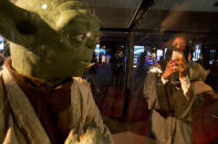 FILE - In this Friday, Feb. 17, 2017, file photo, a visitor films at the Star Wars exhibition, an American epic space franchise, centered on a film series, during the Saudi Comic Con (SCC) which is the first event of its kind to be held in Jiddah, Saudi Arabia. The kingdom, which bans movie theaters and other entertainment venues, is challenging its ultraconservative image and loosening the reins on fun by opening its doors to live shows, including some American ones. (AP Photo, File)