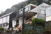 Emergency workers at Sandplace Road, Looe, Cornwall, where heavy rain has caused the collapse of a house (SWNS)