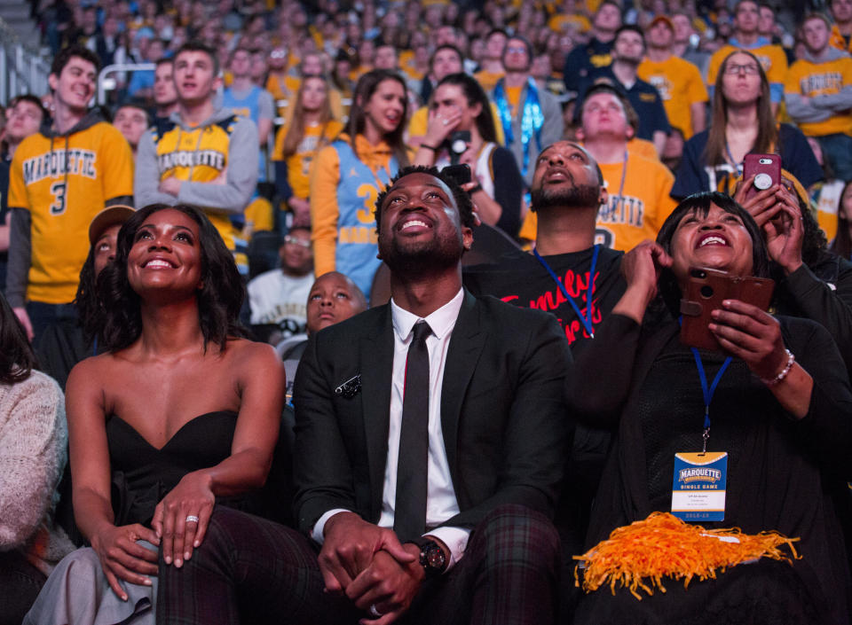 Miami Heat player and Marquette alumni Dwyane Wade, center, is honored with Dwyane Wade Day during half time as Marquette takes on Providence for an NCAA college basketball game Sunday, Jan. 20, 2019, in Milwaukee. (AP Photo/Darren Hauck)