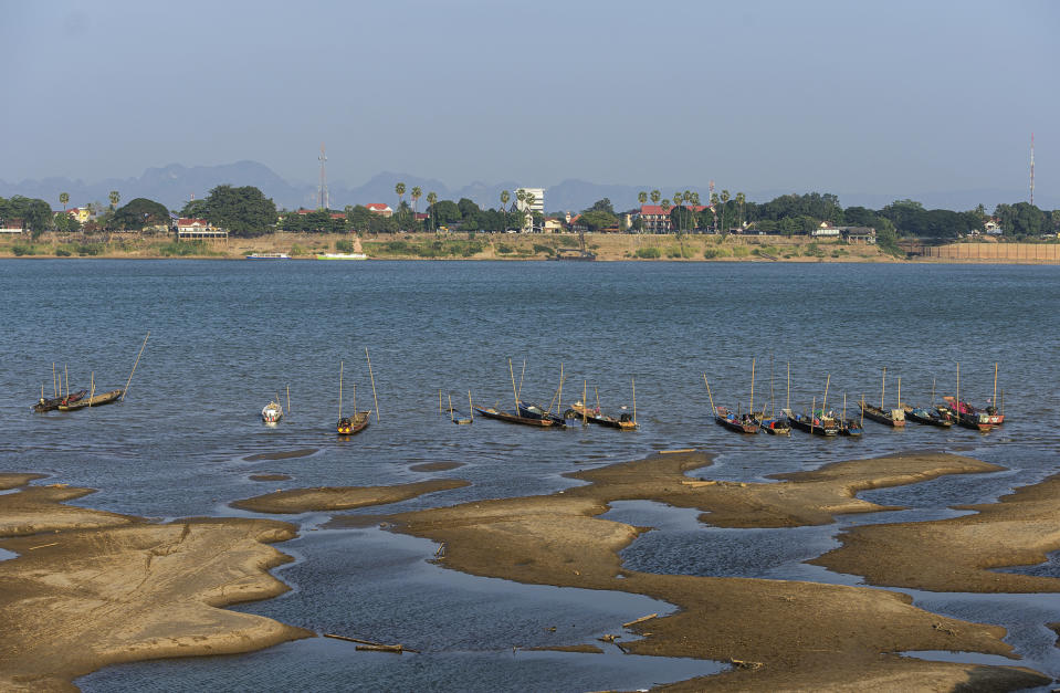 In this Wednesday, Dec. 4, 2019, photo, fishing boats are moored in Mekong River, which has turned blue instead of its usual muddy color, in Nakhon Phanom province, northeastern Thailand. Experts say the aquamarine color the Mekong River has recently acquired may beguile tourists but it also indicates a problem caused by upstream dams. The water usually is a yellowish-brown shade due to the sediment it normally carries downstream. But lately it has been running clear, taking on a blue-green hue that is a reflection of the sky. The water levels have also become unusually low, exposing sandbanks in the middle of the river. (AP Photo/Chessadaporn Buasai)