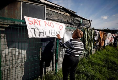 Residents put up banners as community members gather in a park to discuss gang violence in Manenberg township, Cape Town