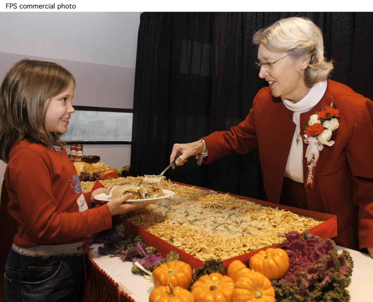 Dorcas Reilly, right, inventor of the Campbell's Soup Green Bean casserole serves a helping of the casserole to Dominique Cupp, 8, from Roosevelt Elementary School in Hubbard, OH, at the National Inventors Hall of Fame in Akron, OH, Tuesday, Nov. 19, 2002. The original recipe of the casserole was donated to the Hall of Fame archives by Reilly, former manager of Campbell's kitchens. The caserole has become a favorite during the holiday season alongside the turkey in over 20 million homes. (Feature PhotoService)