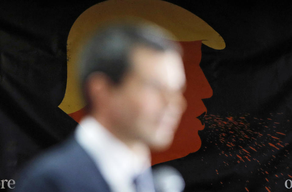 With a poster against President Donald Trump behind him, democratic presidential candidate South Bend Mayor Pete Buttigieg speaks at a culinary workers union hall Saturday, Jan. 11, 2020, in Las Vegas. (AP Photo/John Locher)