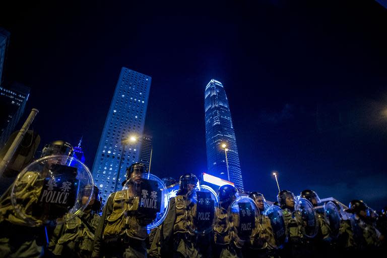 Police officers stand in front of pro-democracy protesters in Hong Kong