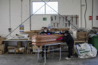 Two employees of CHAO coffins work at the company warehouse in Valdemoro, outskirts of Madrid, Spain, Friday, April 3, 2020. The new coronavirus causes mild or moderate symptoms for most people, but for some, especially older adults and people with existing health problems, it can cause more severe illness or death. (AP Photo/Bernat Armangue)