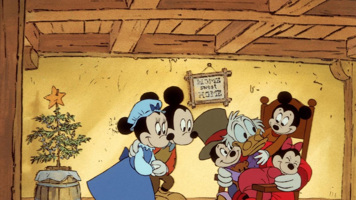 the cratchitt family gathers around scrroge in a scene from mickey's christmas carol, a good housekeeping pick for best christmas movies for kids