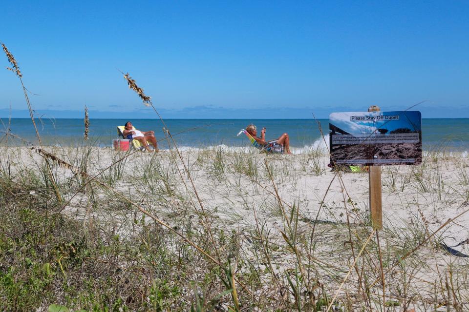 Beachgoers sunbathe on the dunes of Treasure Shores Beach Park, an unguarded beach north of Windsor in Vero Beach on Friday, Sept. 30, 2022, a day after Hurricane Ian impacted the Treasure Coast with strong winds, rain and beach erosion.