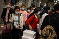 Travellers arrive at a train station ahead of China's upcoming Golden Week holiday following the coronavirus disease (COVID-19) outbreak, in Beijing