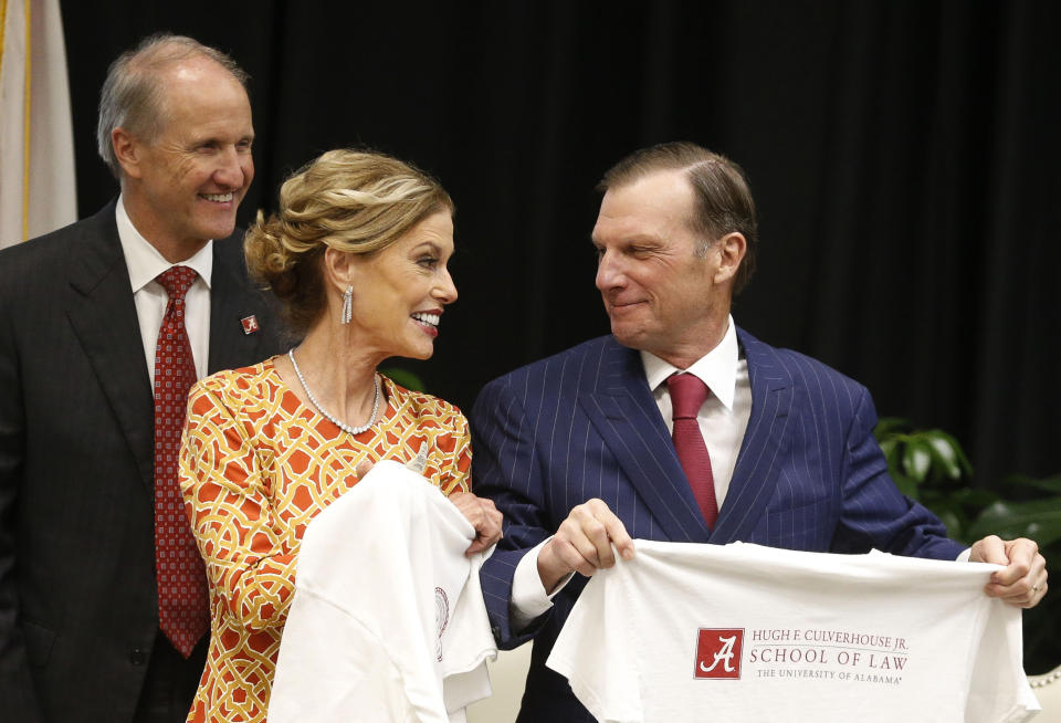 FILE - In this Sept. 20, 2018, file photo, Hugh F. Culverhouse Jr., right, and wife, Eliza show off T-shirts from the the University of Alabama law school, which now bears his name in Tuscaloosa, Ala. The University of Alabama released a selection of emails Sunday, June 9, 2019. showing its relationship soured with Culverhouse long before he called on students to boycott enrolling at the school over the state’s hardline anti-abortion legislation. (Gary Cosby Jr./The Tuscaloosa News via AP, File)