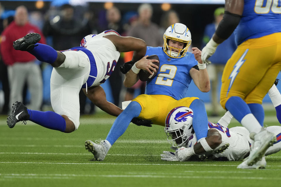 Los Angeles Chargers quarterback Easton Stick (2) is tackled by a pair of Buffalo Bills defenders during the second half of an NFL football game Saturday, Dec. 23, 2023, in Inglewood, Calif. (AP Photo/Ryan Sun)