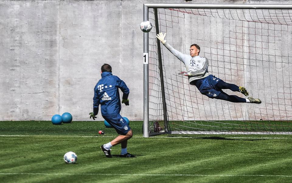 Bayern Munich's goalkeeper Manuel Neuer (R) performs during his team's training session at the German Bundesliga club's ground in Munich - Shutterstock