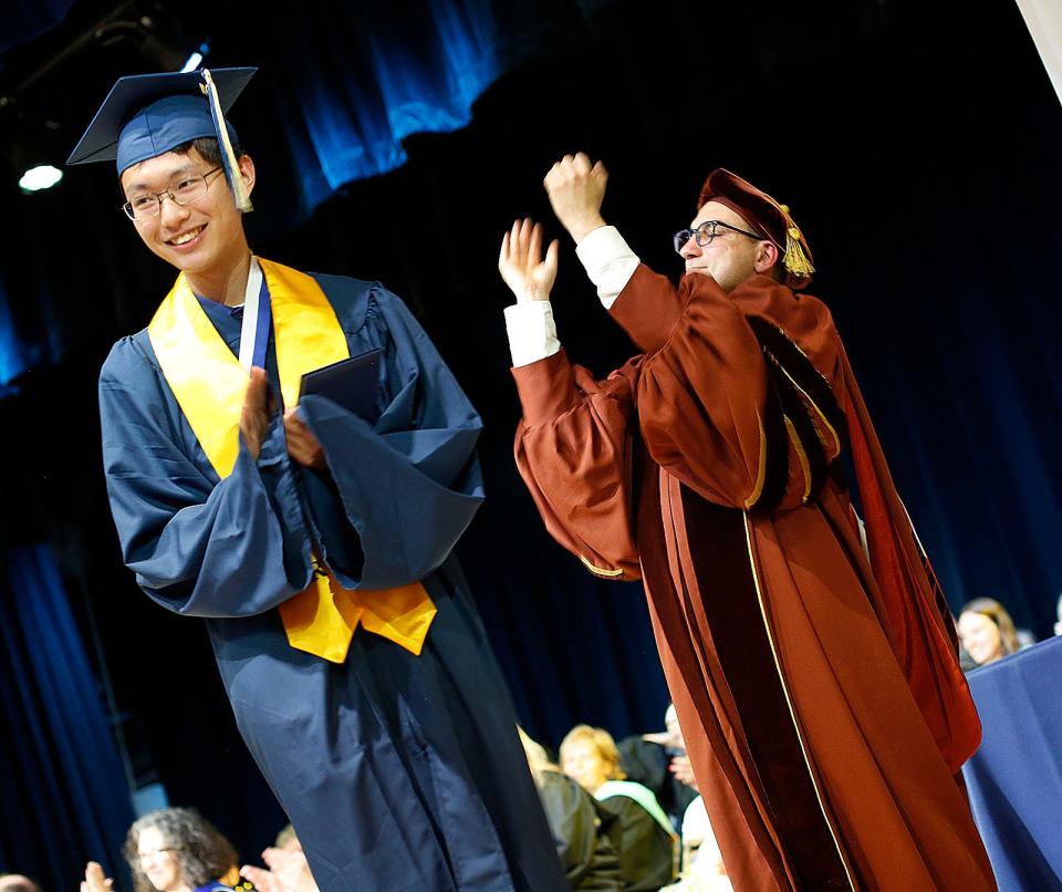 Daniel Weng gets his diploma and applause from principal Michael Volonnino at Archbishop Williams graduation on May 26, 2022.