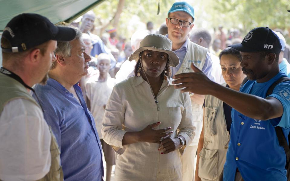 In this photo taken Tuesday, April 1, 2014 and released by the World Food Programme (WFP), WFP Executive Director Ertharin Cousin, center, and UN Refugee Agency (UNHCR) High Commissioner Antonio Guterres, center-left, visit a food distribution site in Nyal, Unity State, South Sudan. Desperate South Sudan villagers, fleeing fighting across the country, are eating grass and roots to survive as WFP starts costly air drops of food, three times more expensive than road deliveries, to northern parts of the country, straining the ramped-up humanitarian response because only a third of the U.N.'s requested $1.27 billion has been raised for the crisis. (AP Photo/WFP, Giulio d'Adamo)