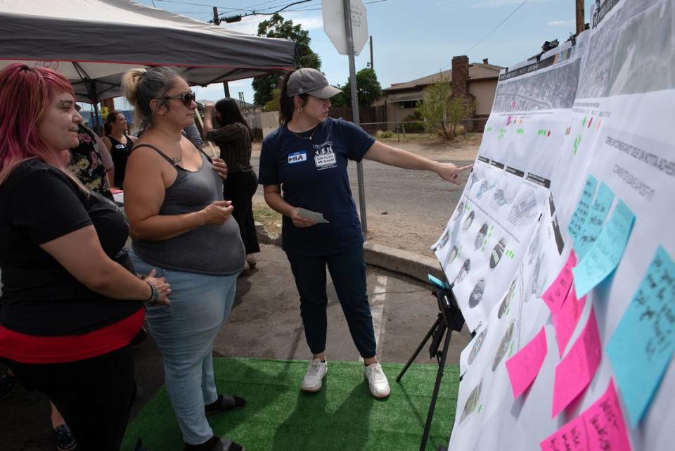 Bystrom residents Denise and Linda Espinoza look at traffic design concepts with traffic planner Mia Candy, right, during a pop-up meeting to gain input from residents on what changes they would like to see in their south Modesto neighborhood on Friday, August 5, 2022.