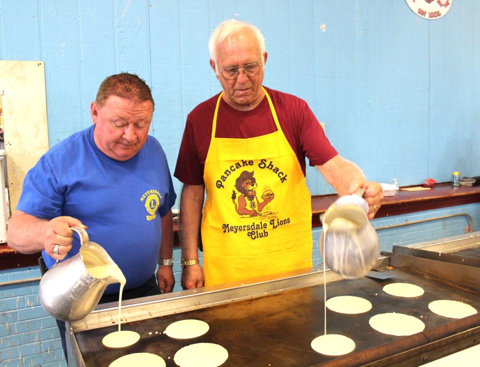 Pancakes served up fresh with sausage and pure maple syrup is part of the tradition at the Pa. Maple Festival at the Lions Pancake Shack. Clarence Baer and Mike Sipple are shown volunteering by pouring batter during last year's festival.