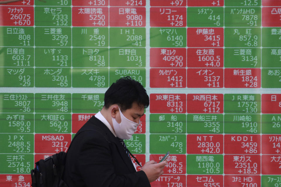 A man walks by an electronic stock board of a securities firm in Tokyo, Wednesday, March 10, 2021. Shares are higher in Asia after gains for major tech companies powered a 3.7% surge in the Nasdaq, the largest jump for the index in four months. (AP Photo/Koji Sasahara)