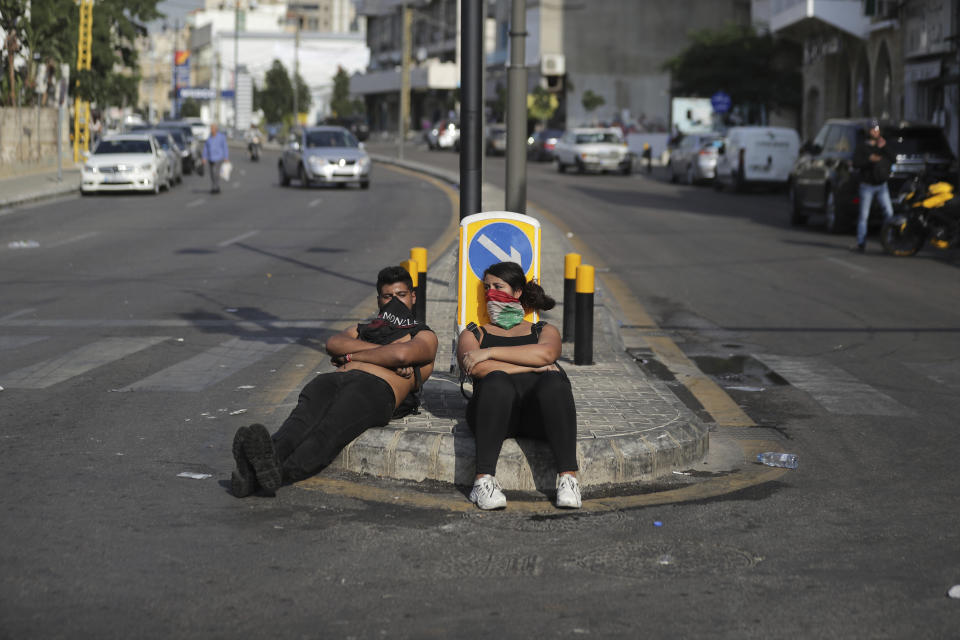 Anti-Government protesters sit while monitoring a roadblock, in the town of Jal el-Dib, north of Beirut, Lebanon, Wednesday, Nov. 13, 2019. Lebanese protesters said they will remain in the streets despite the president's appeal for them to go home. (AP Photo/Hassan Ammar)