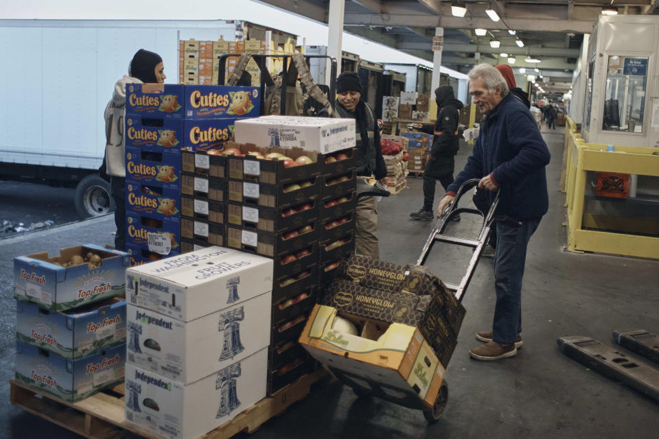 People shop fresh fruits and vegetables at S. Katzman Produce inside the Hunts Point Produce Market on Tuesday, Nov. 22, 2022, in the Bronx borough of New York. Hunts Point's wholesalers distribute 2.5 billion pounds of produce a year, with about 30 million pounds having moved on Tuesday alone. The produce ends up at places like Whole Foods, high-end grocers and specialty markets, as well smaller mom-and-pop outlets. Thanksgiving is especially busy time of year because the quintessentially American feast is universally celebrated across the United States. (AP Photo/Andres Kudacki)