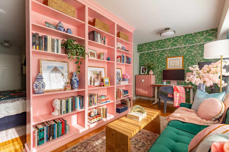 Pink bookshelf in colorful living room.