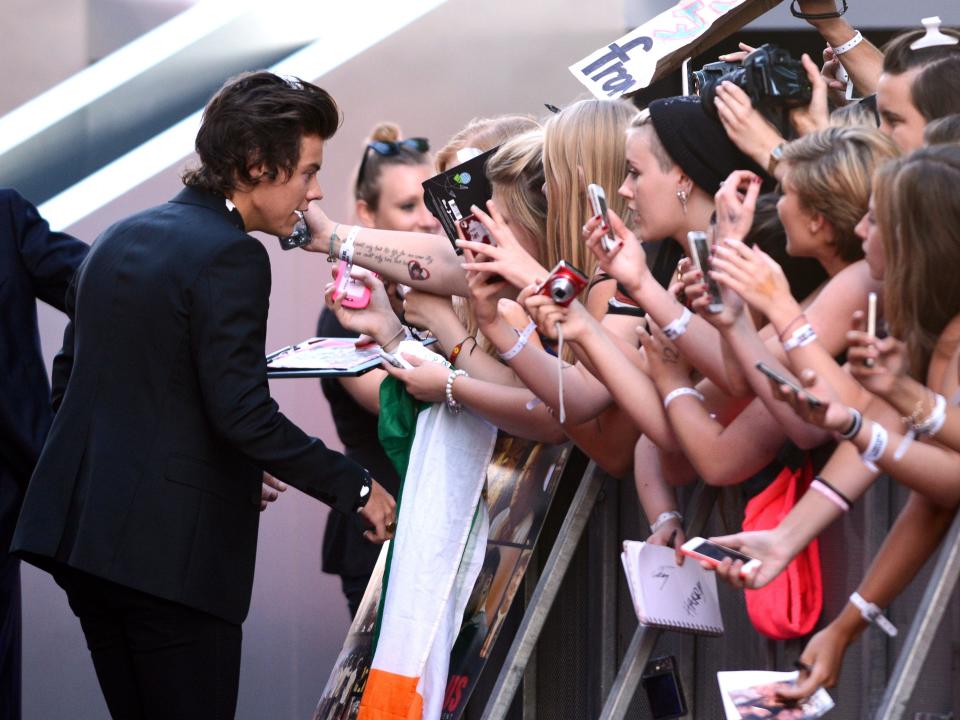 harry styles signing autographs for fans at this is us movie premiere in 2013