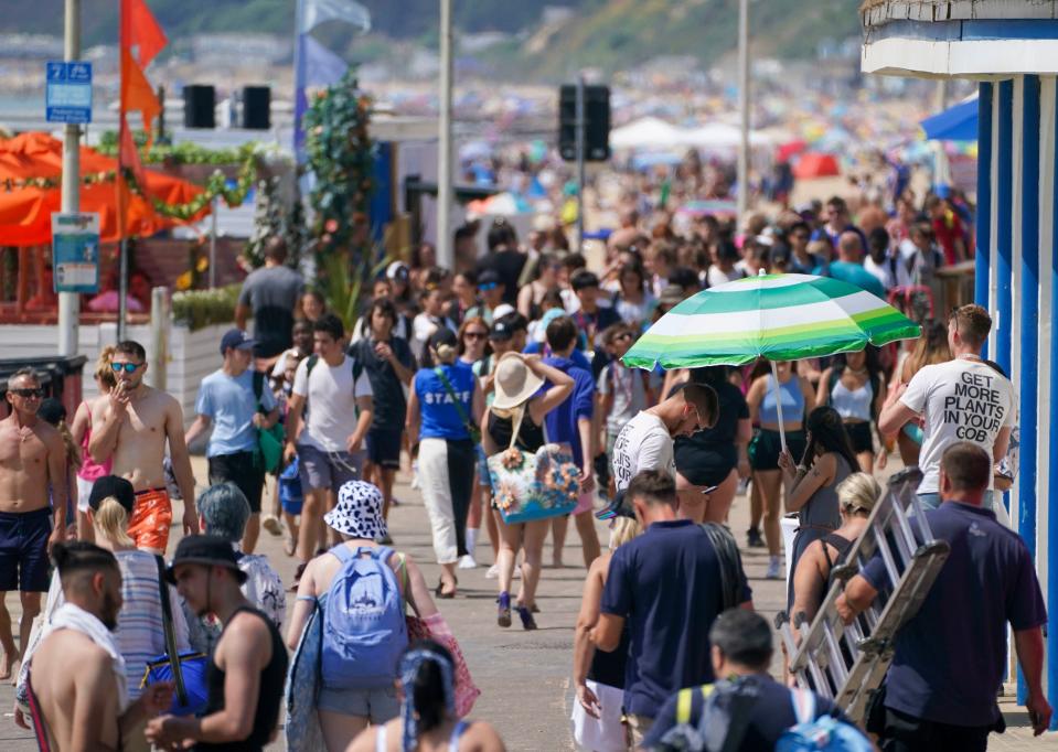 People walk along the promenade near the beach in Bournemouth (PA)