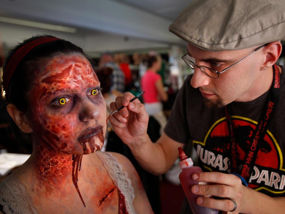 Woman performing as a scareactor gets her makeup done before Halloween Horror Nights.