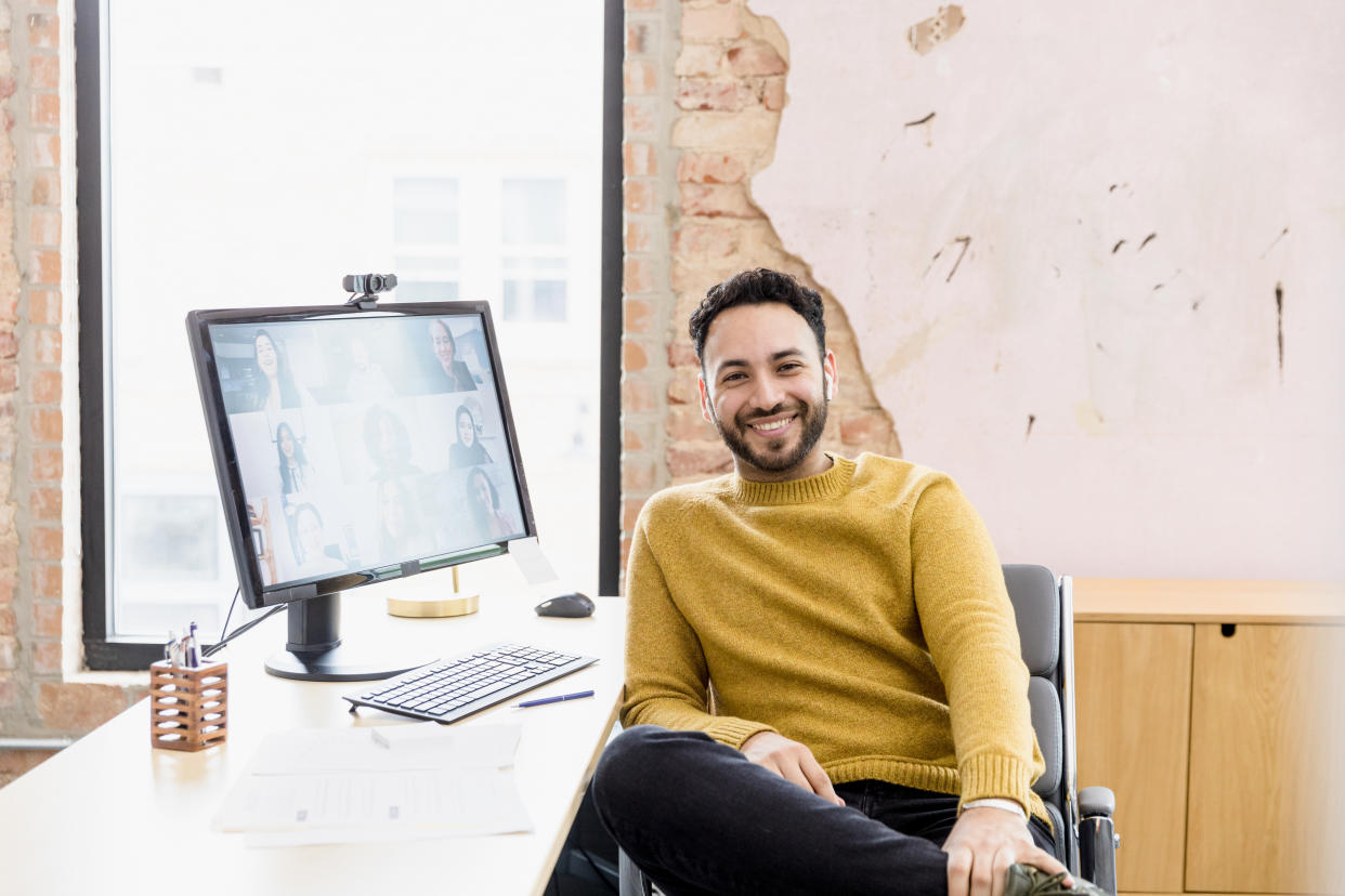 The small business owner poses at his home office computer for a portrait.