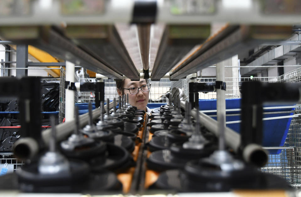 A factory worker checks parts at a manufacturing plant for automobile air conditioners in Yantai in eastern China's Shandong province, Wednesday, May 15, 2019. China's factory output and consumer spending weakened in April as a tariff war with Washington intensified, stepping up pressure on Beijing to shore up economic growth. (Chinatopix via AP)