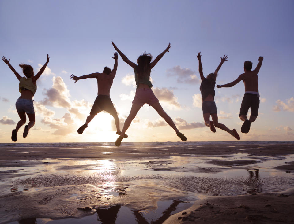 People jumping in the air at a beach