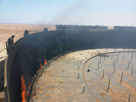 Smoke and flame rise from an oil storage tank that was set on fire amid fighting between rival factions at Ras Lanuf terminal, Libya in this handout picture released on June 16, 2018. The National Oil Corporation/ Handout via Reuters