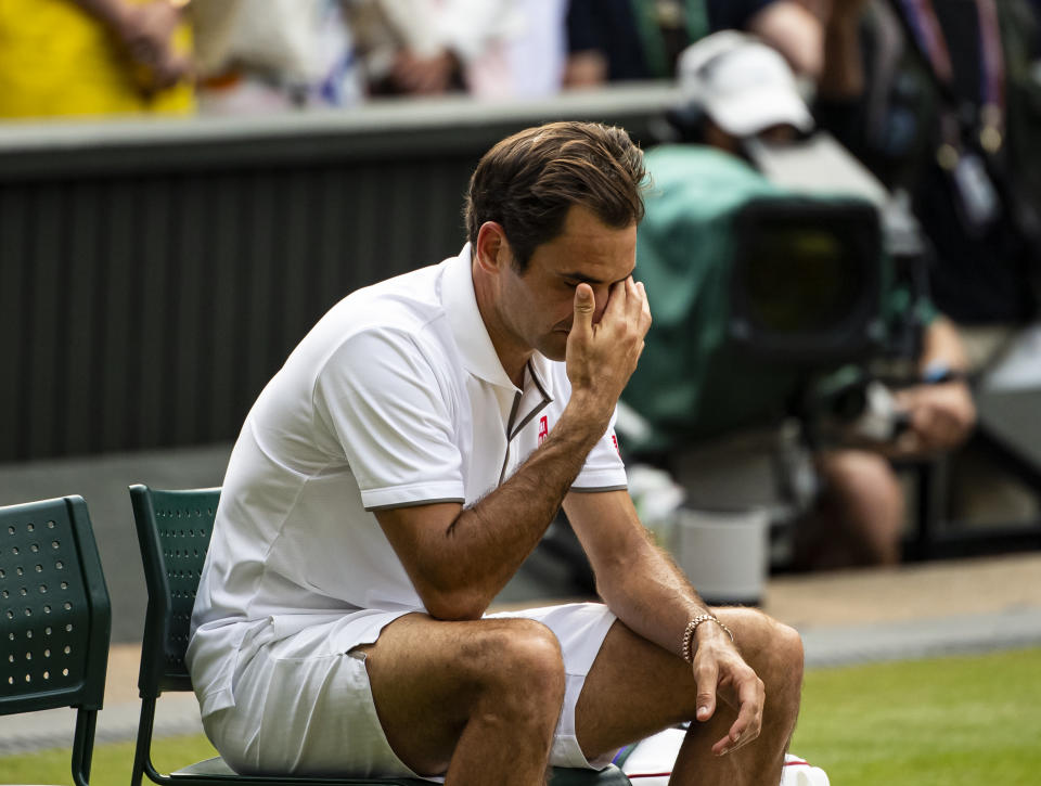 Roger Federer covers his face and looks dejected after losing.