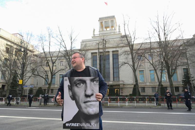 An activist stands in front of the Russian embassy in Berlin with a poster of Russian activist Alexei Navalny. Leading Russian opposition figure Alexei Navalny has died in prison on Friday at the age of 47. Paul Zinken/dpa