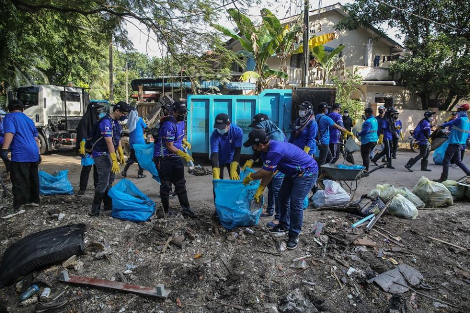 People work together to clean up the area of Taman Sri Muda in Shah Alam January 8, 2022.