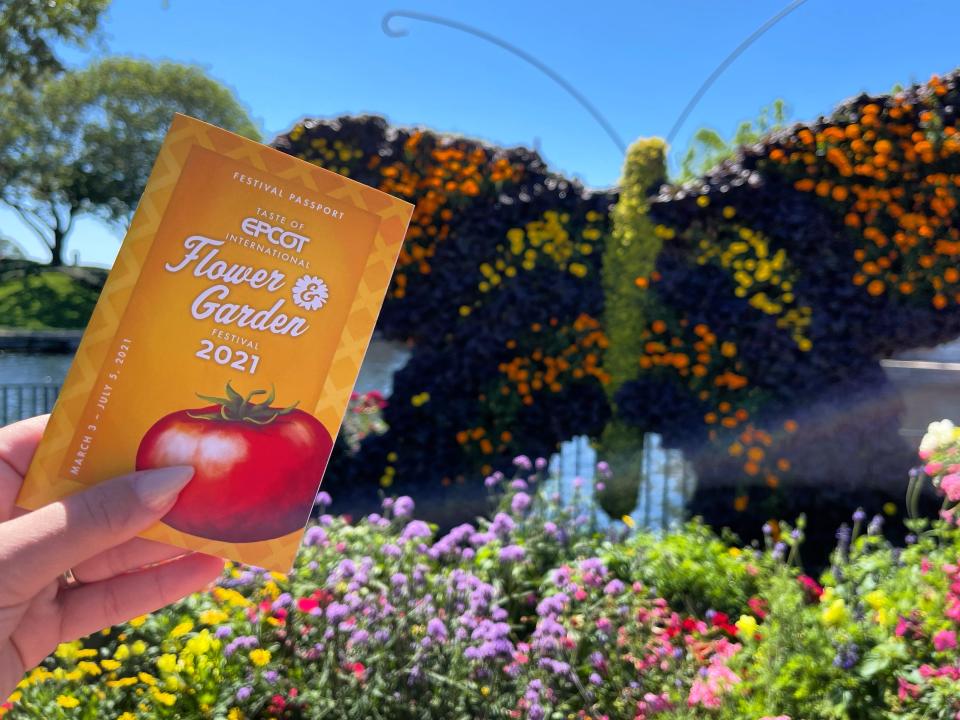 hand holding epcot flower and garden festival pamphlet at epcot disney world