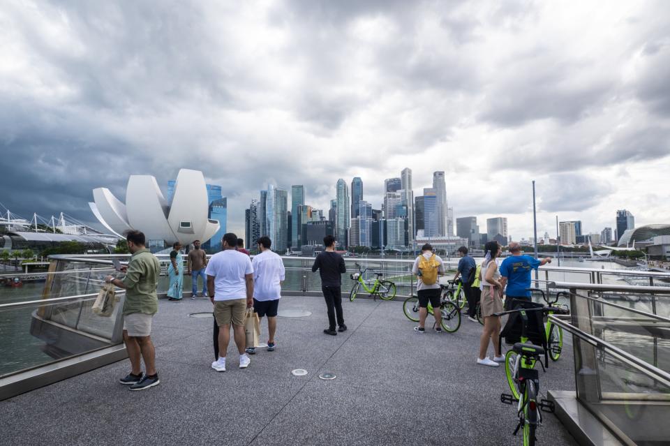 People take photographs at the Helix Bridge in Singapore, on Saturday, Feb. 11, 2023.