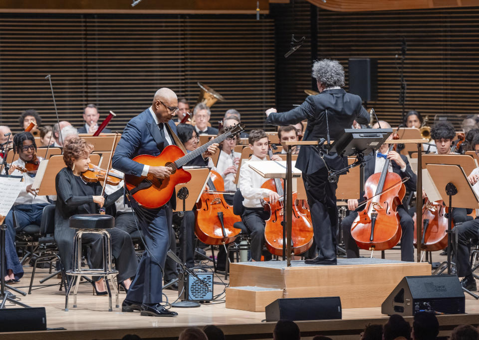 This image released by the New York Philharmonic shows former New York Yankees baseball player Bernie Williams, standing left, with conductor Gustavo Dudamel as he makes his New York Philharmonic debut in New York on Wednesday, April 24, 2024. (Brandon Patoc/New York Philharmonic via AP)