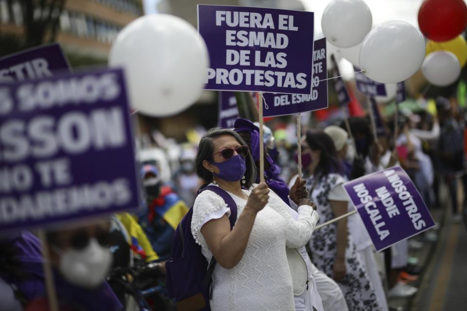 A protester holds a sign demanding police stay out of protests during an anti-government march in Bogota, Colombia, Wednesday, May 19, 2021. Colombians have taken to the streets for weeks across the country after the government proposed tax increases on public services, fuel, wages and pension. (AP Photo/Ivan Valencia)