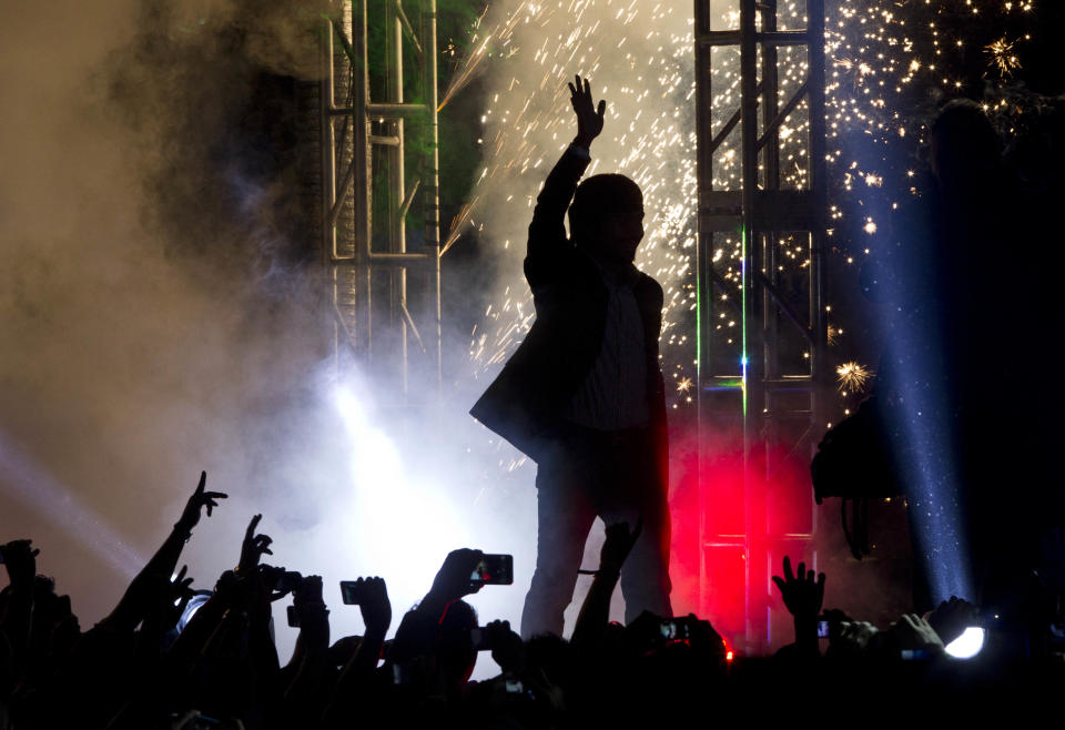 WBO welterweight champion boxer Manny Pacquiao, of the Philippines, waves as fireworks explode behind him during a boxing presentation in Mexico City, Friday, Sept. 21, 2012. Pacquiao and his Mexican challenger Juan Manuel Marquez are promoting their fourth fight, scheduled for Dec. 8, 2012 in Las Vegas. (AP Photo/Christian Palma)