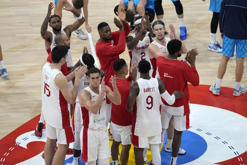 Members of team Canada celebrate after defeating Slovenia in a Basketball World Cup quarterfinal game in Manila, Philippines, Wednesday, Sept. 6, 2023. (AP Photo/Aaron Favila)