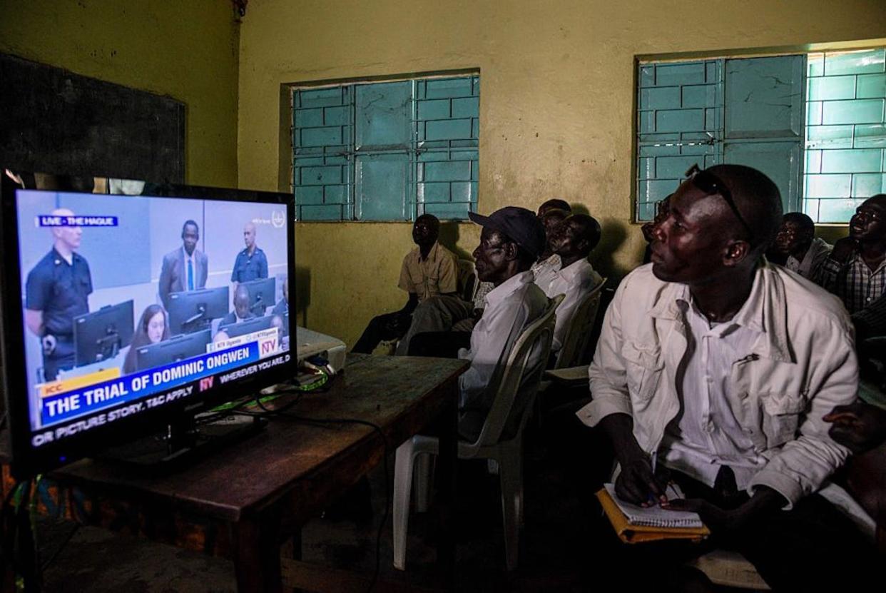 Ugandans watch the start of the International Criminal Court trial of former child soldier-turned-warlord Dominic Ongwen. <a href="https://www.gettyimages.com/detail/news-photo/residents-watch-the-screening-of-the-start-of-the-icc-trial-news-photo/628000204?adppopup=true" rel="nofollow noopener" target="_blank" data-ylk="slk:Isaac Kasamani/AFP via Getty Images;elm:context_link;itc:0;sec:content-canvas" class="link ">Isaac Kasamani/AFP via Getty Images</a>