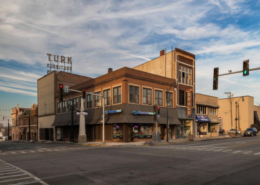 Large brown brick building situated at the corner of intersection. 