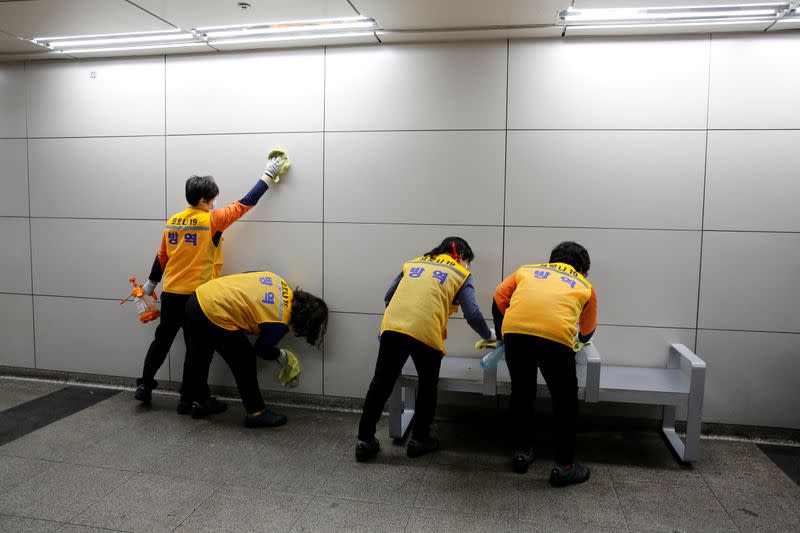 Employees from a disinfection service company sanitize a subway station amid coronavirus fears in Seoul