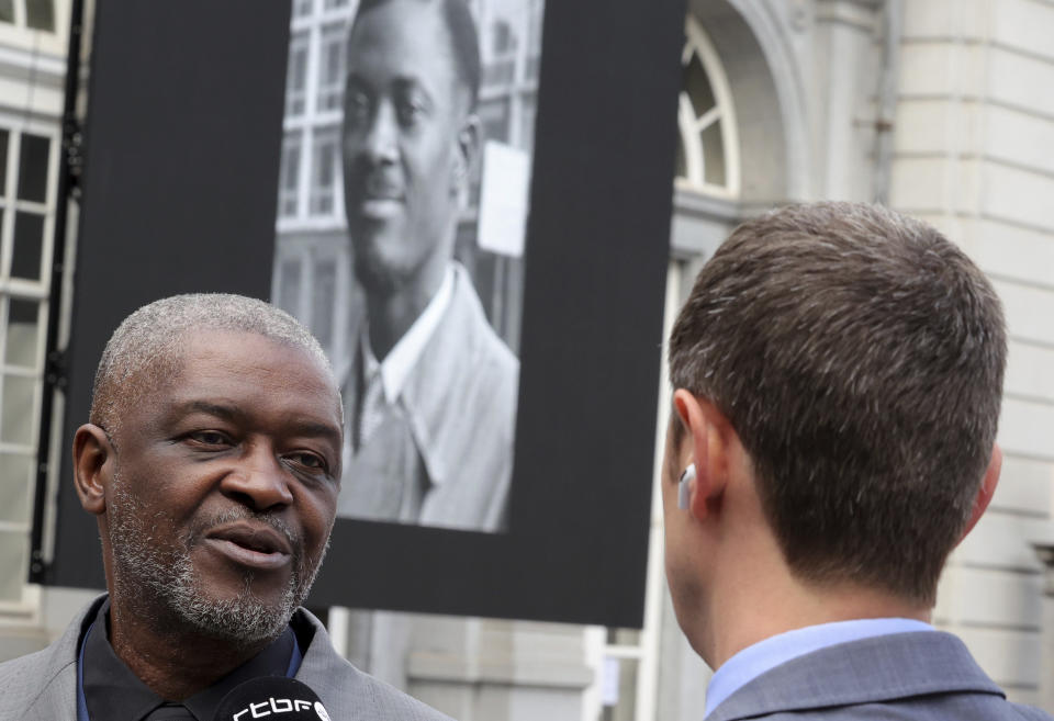 Roland Lumumba, the son of Patrice Lumumba, left, speaks with the media as he arrives for a ceremony at the Egmont Palace in Brussels, Monday, June 20, 2022. On Monday, more than sixty one years after his death, the mortal remains of Congo's first democratically elected prime minister Patrice Lumumba will be handed over to his children during an official ceremony in Belgium. (AP Photo/Olivier Matthys, Pool)