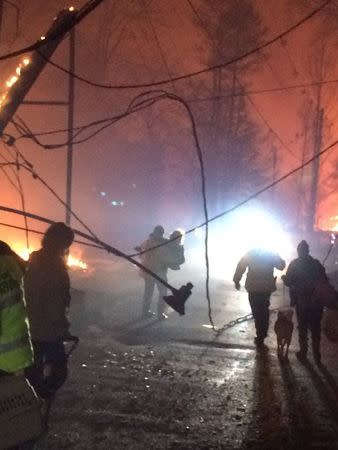 Troopers from the Tennessee Highway Patrol help residents leave an area under threat of wildfire after a mandatory evacuation was ordered in Gatlinburg, Tennessee in a picture released November 30, 2016. Tennessee Highway Patrol/Handout via REUTERS