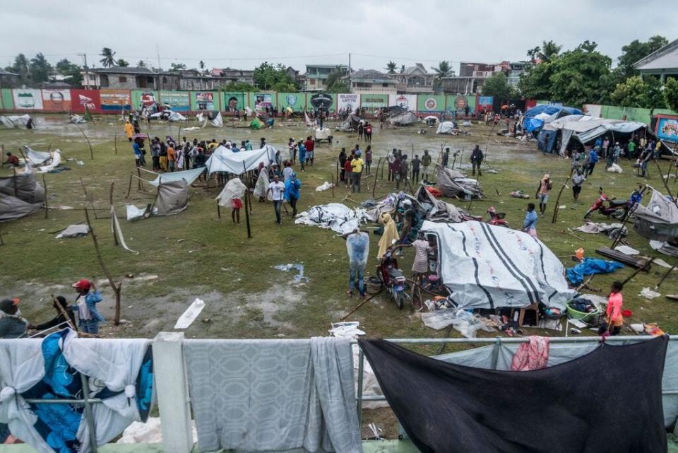 People make repairs and set up shelters after spending the night outside in the aftermath of an earthquake, facing the severe inclement weather of Tropical Storm Grace near Les Cayes, Haiti, on Aug. 17.