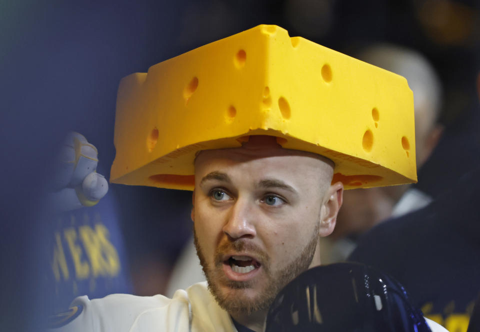 Milwaukee Brewers' Mike Brosseau (10) wears a cheese hat in the dugout after hitting a home run against the Detroit Tigers during the third inning of a baseball game, Monday, April 24, 2023, in Milwaukee. (AP Photo/Jeffrey Phelps)