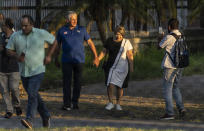 Seen through a fence, Cuba's President Miguel Diaz Canel walks with his wife Lis Cuesta Peraza before casting his vote at a polling station during the new Family Code referendum in Havana, Cuba, Sunday, Sept. 25, 2022. The draft of the new Family Code, which has more than 480 articles, was drawn up by a team of 30 experts, and it is expected to replace the current one that dates from 1975 and has been overtaken by new family structures and social changes. (AP Photo/Ramon Espinosa)