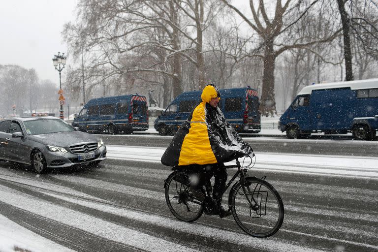 Un hombre circula en bicicleta durante la nevada en París, Francia,